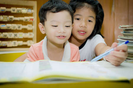 Sister helping brother to writing homeworkの写真素材