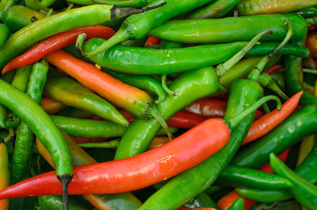 lots of fresh large red spicy chillis shot from overhead at outdoors market