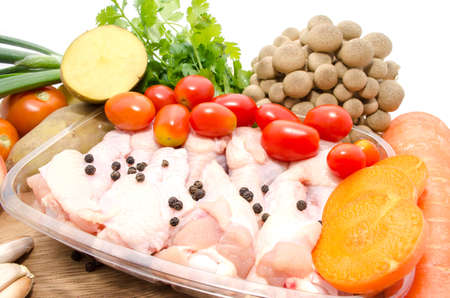 A whole chicken and soup vegetables for a chicken stockの写真素材