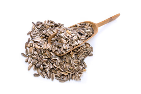 Sunflower seeds in a spoon and near on white backgroundの写真素材