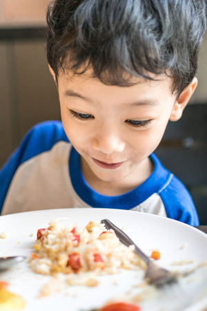 Young boy looking at food excitedly at home, hungryの写真素材
