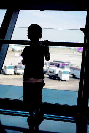 Boy looking at planes in the airportの写真素材