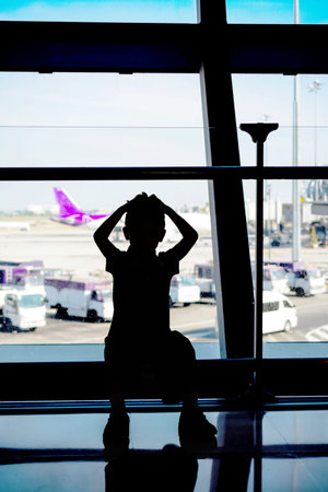 Boy looking at planes in the airportのeditorial素材