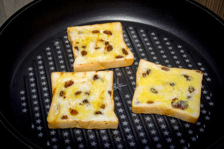 Slice of cereal toast bread  on black panの写真素材