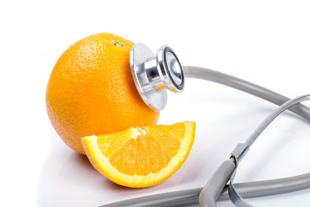 Orange with stethoscope on white backgroundの写真素材