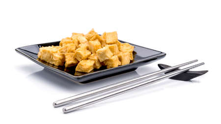 fried tofu, soy products on black plate bowl on white backgroundの写真素材