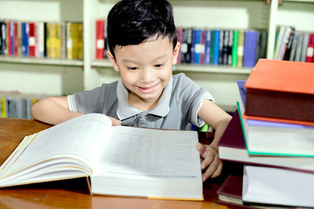 young asian boy with book in Library.