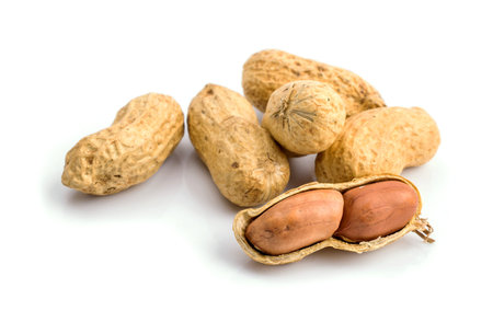 Dried peanuts in closeup on white background.