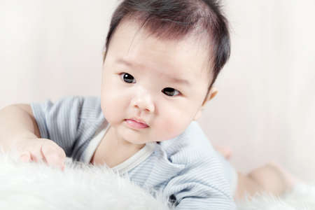 Asian baby boy lying on bedの写真素材