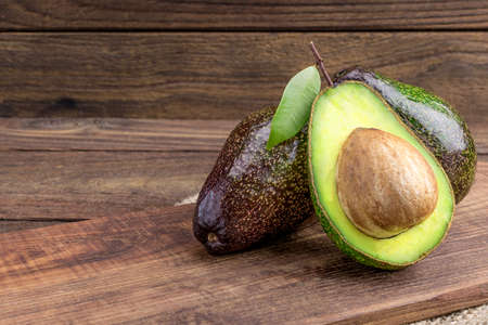 Fresh avocado on cutting board over wooden backgroundの写真素材