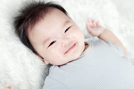 Asian baby boy lying on bedの写真素材