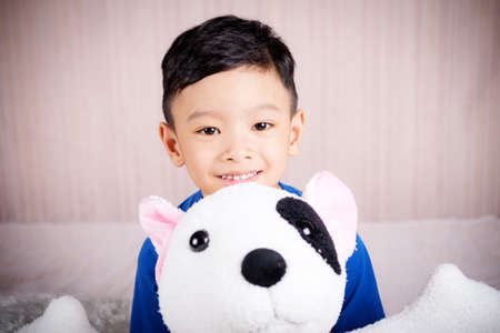 The boy is happy with doll dog lovely friend on the bed, Family Lovely Conceptの写真素材