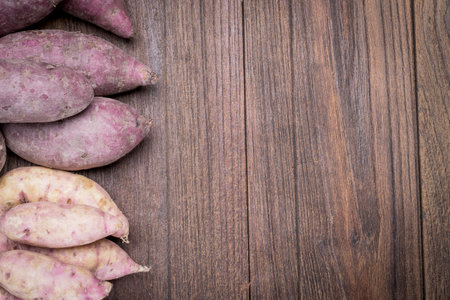 Sweet potatoes beautiful on a wooden table.の写真素材