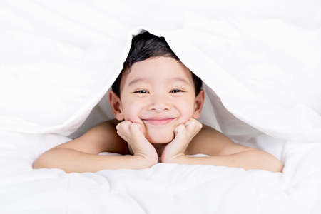 Portrait young Asian boy, cute boy lie on bed.の写真素材