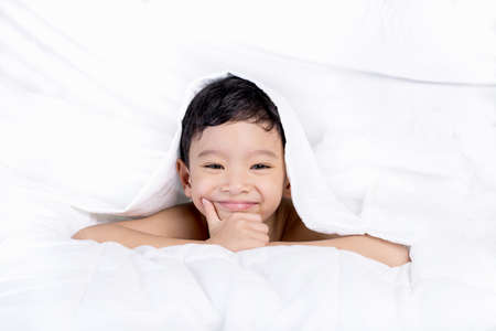 Portrait young Asian boy, cute boy lie on bed.の写真素材