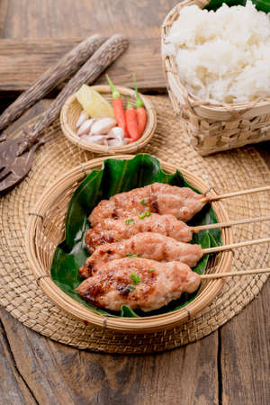 grilled pork with sweet spicy sauce and sticky rice on wooden plate: Thai street food styleの写真素材
