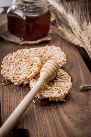 Honey in a jar, wheat and milk on an old vintage wood background from above. Rural or rustic style breakfast concept.の写真素材