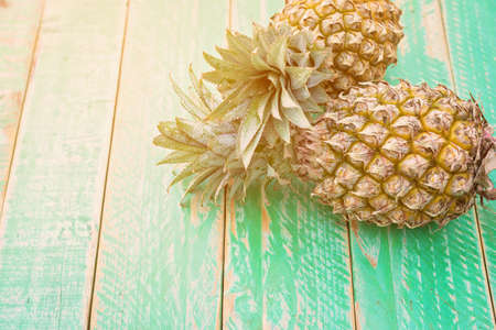 Ripe pineapple on a green wooden backgroundの写真素材