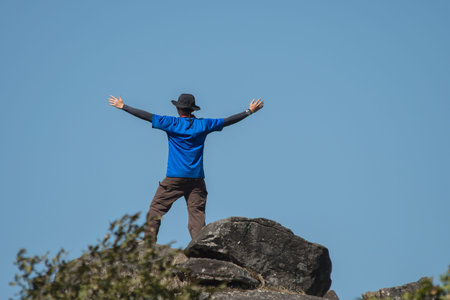 Young successful man open arms on mountain peak above the forest.Thailandの写真素材