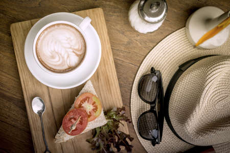 Coffee cup and sandwiches on a wooden table.の写真素材