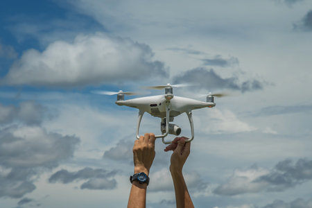 The drone and photographer man hands , The drone with the professional camera takes pictures.