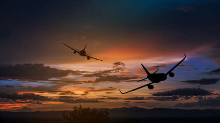 Silhouette from a landing plane that is flying to the airport. Photo taken during a nice colorful sunset.の写真素材