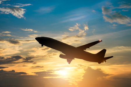 Airplane take off on the blue sky, big jet plane flying on blue cloudy skybackgroundの写真素材