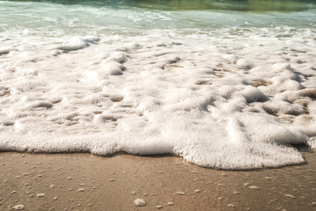 Background soft wave of Sea with foam on sandy beach, copy space.