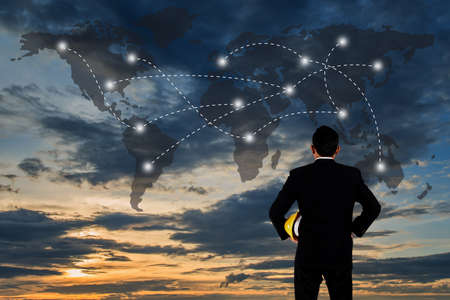 Business Collaboration Concept, World data link connection with male engineer stands in the sunset background for designの写真素材