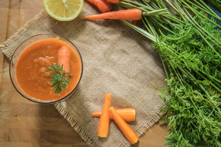 Fresh carrot juice in glasses on rustic wooden table. Natural healthy drink. Selective focus.の写真素材