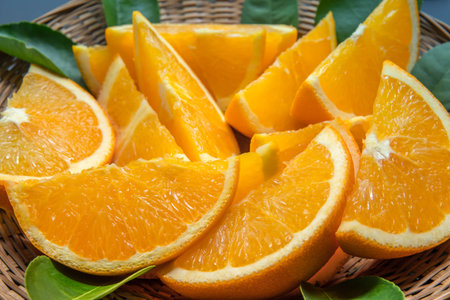 Colorful fruit of fresh orange slices with leaf on black background. From top view