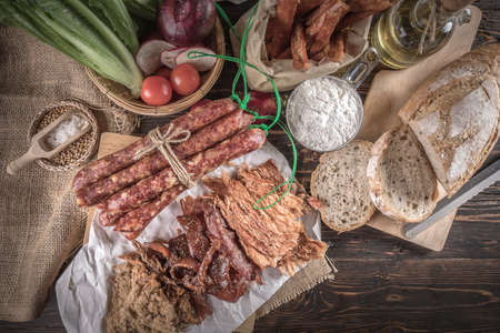 Champagne with delicious pieces of sliced ham, sausage, tomatoes, salad and vegetable - Meat platter with selection - Cutting sausage and cured meat, still life.の写真素材