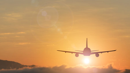 Silhouette from a landing plane that is flying to the airport. Photo taken during a nice colorful sunset.の写真素材