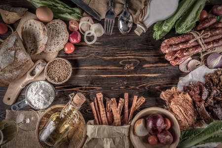Bread with delicious pieces of sliced ham, sausage, tomatoes, salad and vegetable - Meat platter with selection - Cutting sausage and cured meat, still life.の写真素材