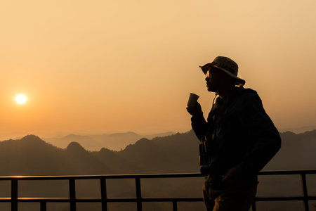 Silhouette of a photographer who was happy to shoot in the morning, a beautiful nature の写真素材
