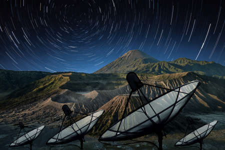 Big black Satellite Dish on star trail sky backgroundの写真素材