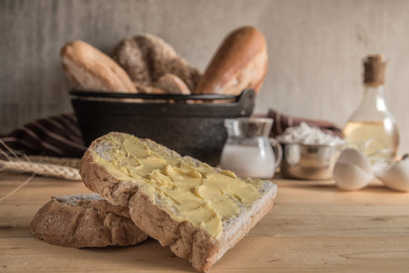 Male baker prepares bread. Male baker sprinkle the dough with flour. Making bread. Top view. Rustic style, Different kinds of bread rolls on table wooden from above. Kitchen or bakery poster designの写真素材