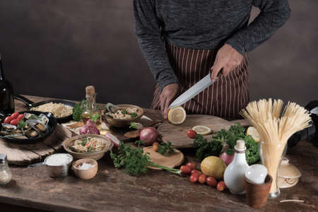 Handsome bearded cheef cook prepairing spaghetti on a kitchen, Chef cooks mealの写真素材