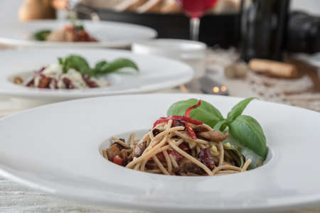 Close up low angle view of a plate of spaghetti topped with delicious bolognaise sauce and basilの写真素材