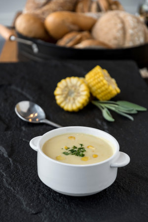 Corn soup in bowl with fresh corn cob on the side.の写真素材