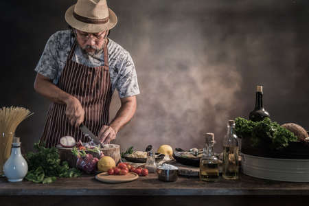 Handsome bearded cheef cook prepairing spaghetti on a kitchen, Chef cooks mealの写真素材