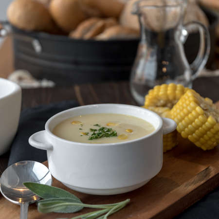 Corn soup in bowl with fresh corn cob on the side.の写真素材