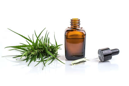 cannabis essential oil container with cannabis leaves on white background.の写真素材