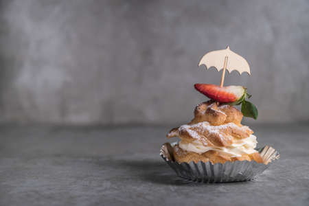 Homemade profiteroles with cream, strawberries and mint. Dessert for gourmets. Selective focusの写真素材