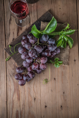 Healthy fruits Red grapes in the vineyard, bunch of grapes on the wooden table ready to eat.