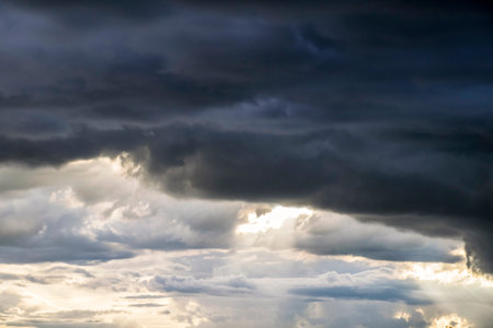 Light in the Dark and Dramatic Storm Clouds background, Black cumulus clouds before the beginning of...