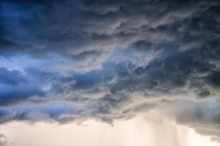 Light in the Dark and Dramatic Storm Clouds background, Black cumulus clouds before the beginning of a strong stormの写真素材