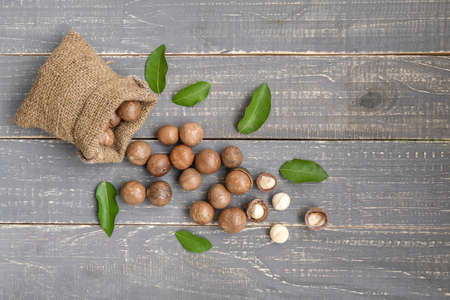 Organic Macadamia nut on wooden table - vintage filter, Closeup view of natural macadamia oil and Macadamia nuts on wooden board. Healthy productの写真素材