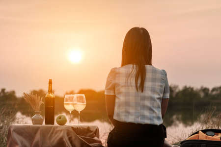 Happy life moments. Couple enjoying the sunset while having a glass of wine.の写真素材