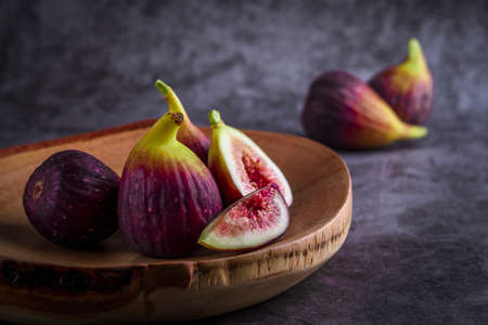 Fresh ripe figs on dark table. Healthy mediterranean fig fruit. Fresh figs on black background. Beautiful blue violet figs with empty copyspace close upの写真素材